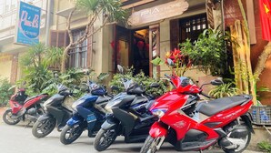 Uma fileira de motocicletas estacionadas em frente a um prédio com uma placa que diz 'Pia's Home'.