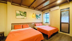 Quarto com duas camas, piso de madeira, ventoinha no teto e janela com cortinas.