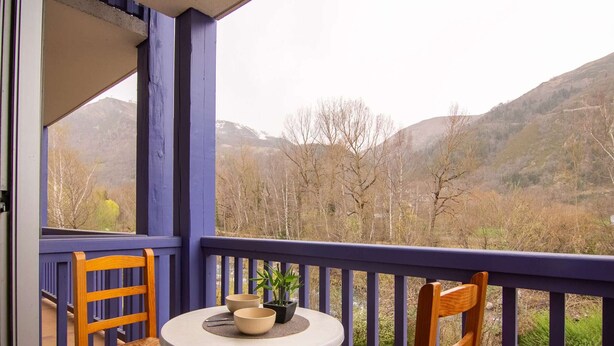 A balcony with two wooden chairs and a small round table, overlooking a mountainous landscape. - Cozy apartment in Vielle Aure for 6 with parking (Vielle-Aure)