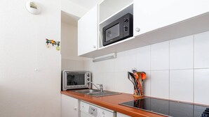 Una cocina compacta equipada con microondas, horno tostador y lavavajillas.