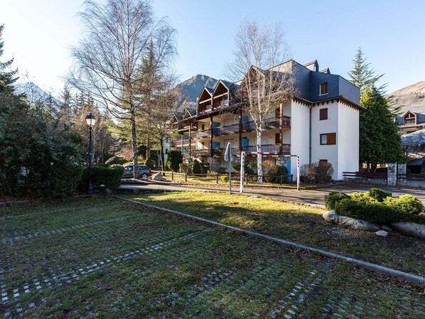 Un hotel de estilo arquitectónico europeo tradicional, con un balcón en el segundo piso y un camino de piedra que conduce a la entrada.