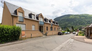 A row of residential buildings with a mountain backdrop.