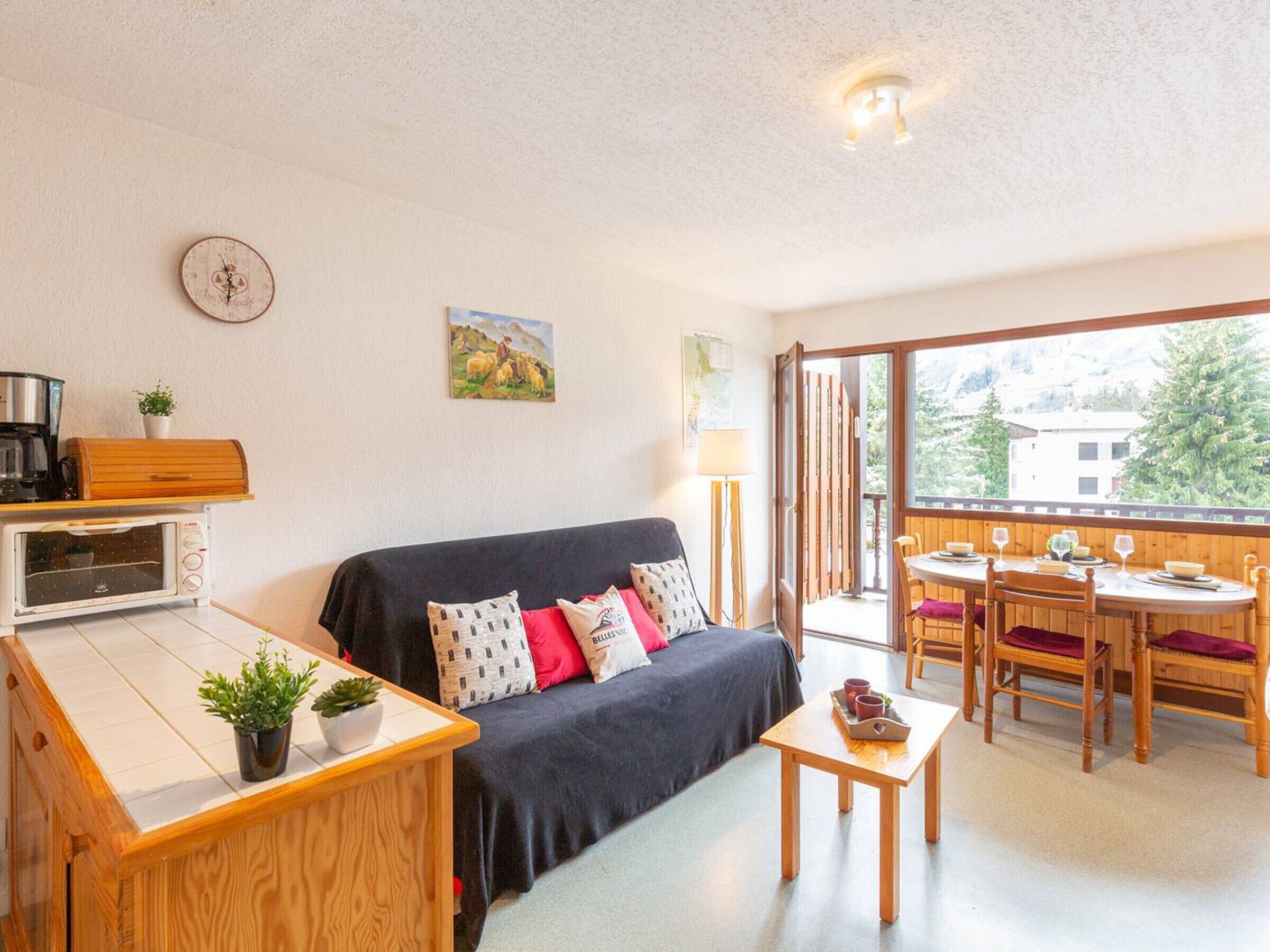 Ett mysigt vardagsrum med en soffa, ett soffbord och en matplats med stolar och ett bord.