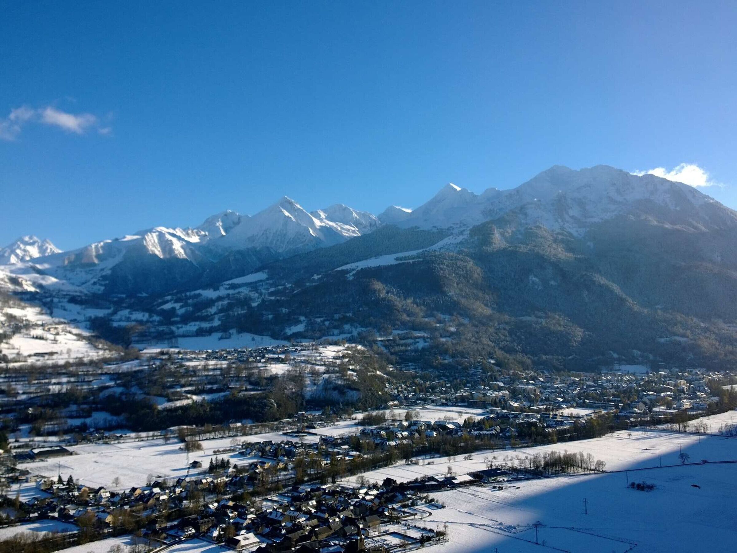 A mountainous landscape with a town in the foreground.