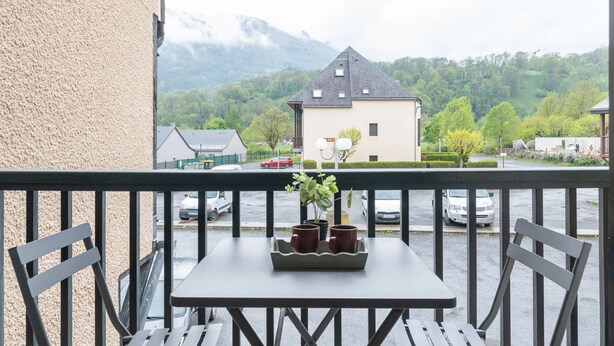 A balcony with a table, chairs, and a potted plant. - Comfortable studio for 4 near cable car in Vielle-Aure (Vielle-Aure)