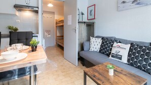 A compact living space with a kitchenette, a dining area, and a seating area with a sofa and a coffee table. - Comfortable studio for 4 near cable car in Vielle-Aure (Vielle-Aure)