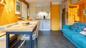 A compact living space with a dining area, kitchenette, and a sofa. - Studio for 4, quiet area near center in Saint-Lary-Soulan (Saint-Lary-Soulan)
