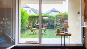 A room with a sliding glass door leading to a backyard with a table, chairs, and a lamp. - Studio for 4, quiet area near center in Saint-Lary-Soulan (Saint-Lary-Soulan)