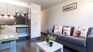 A modern apartment with a kitchen, dining area, and living room. - Renovated apartment for 4, quiet, near Saint-Lary center (Saint-Lary-Soulan)