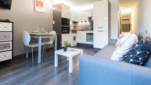 A compact living space with a dining area, kitchenette, and a sofa. - Renovated apartment for 4, quiet, near Saint-Lary center (Saint-Lary-Soulan)