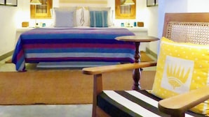 A hotel room with a bed, two wall-mounted lamps, a chair, and a ceiling fan. - Samaragiri (Galle)