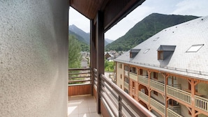 Un balcon offrant une vue sur une montagne et un bâtiment traditionnel doté de nombreux balcons.