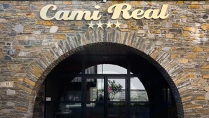 A stone archway entrance to a building with a sign reading "Cami Real" above it. - Duplex Apartment for 8 with Pool and Sauna in City Center (Saint-Lary-Soulan)