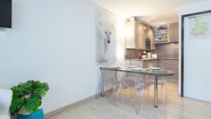 Une cuisine moderne avec un coin repas, une carte accrochée au mur et une plante en pot.