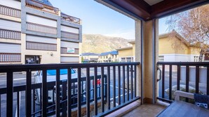 A balcony with a view of a parking lot and buildings.