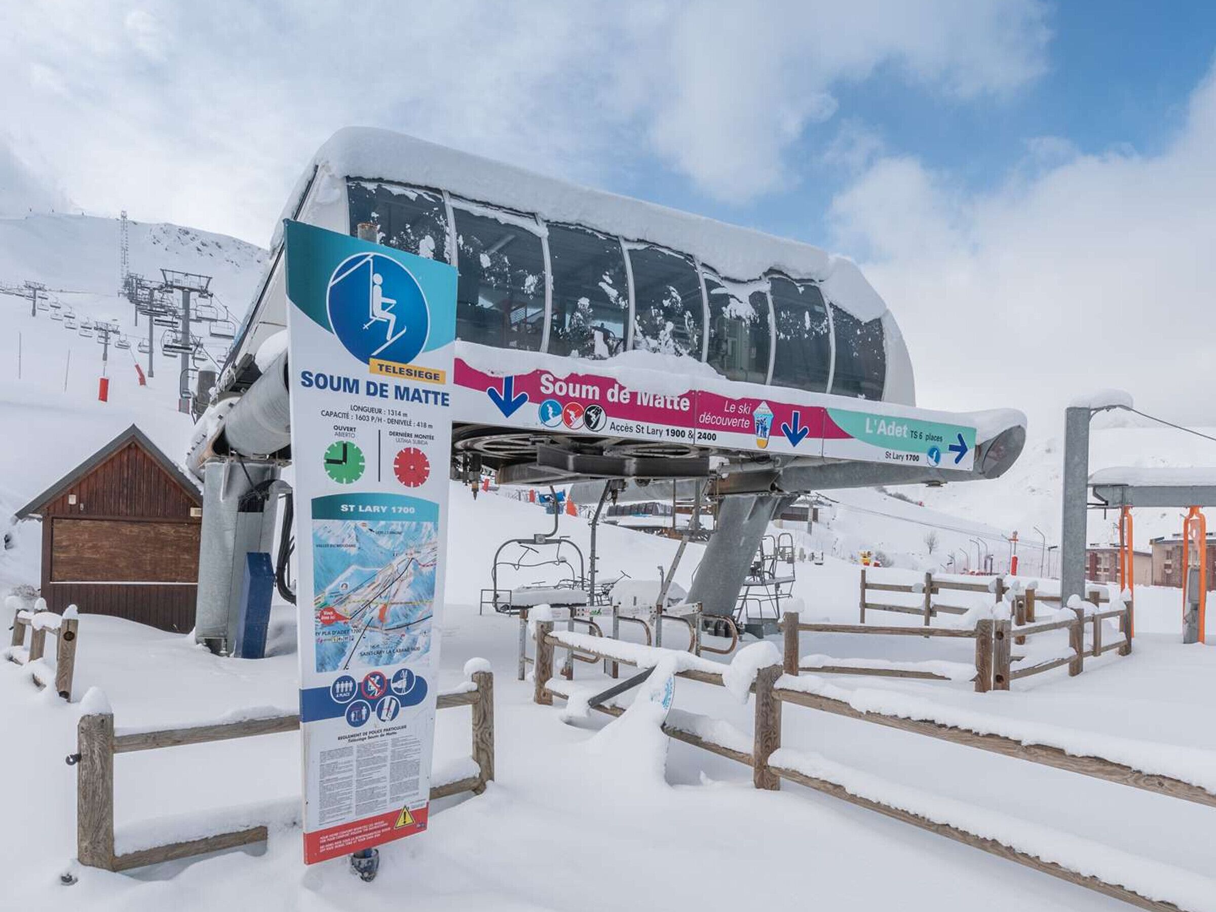 Un telesilla cubierto de nieve con un cartel que indica 'Soum de Matte' y 'Saint Lary 1700'.