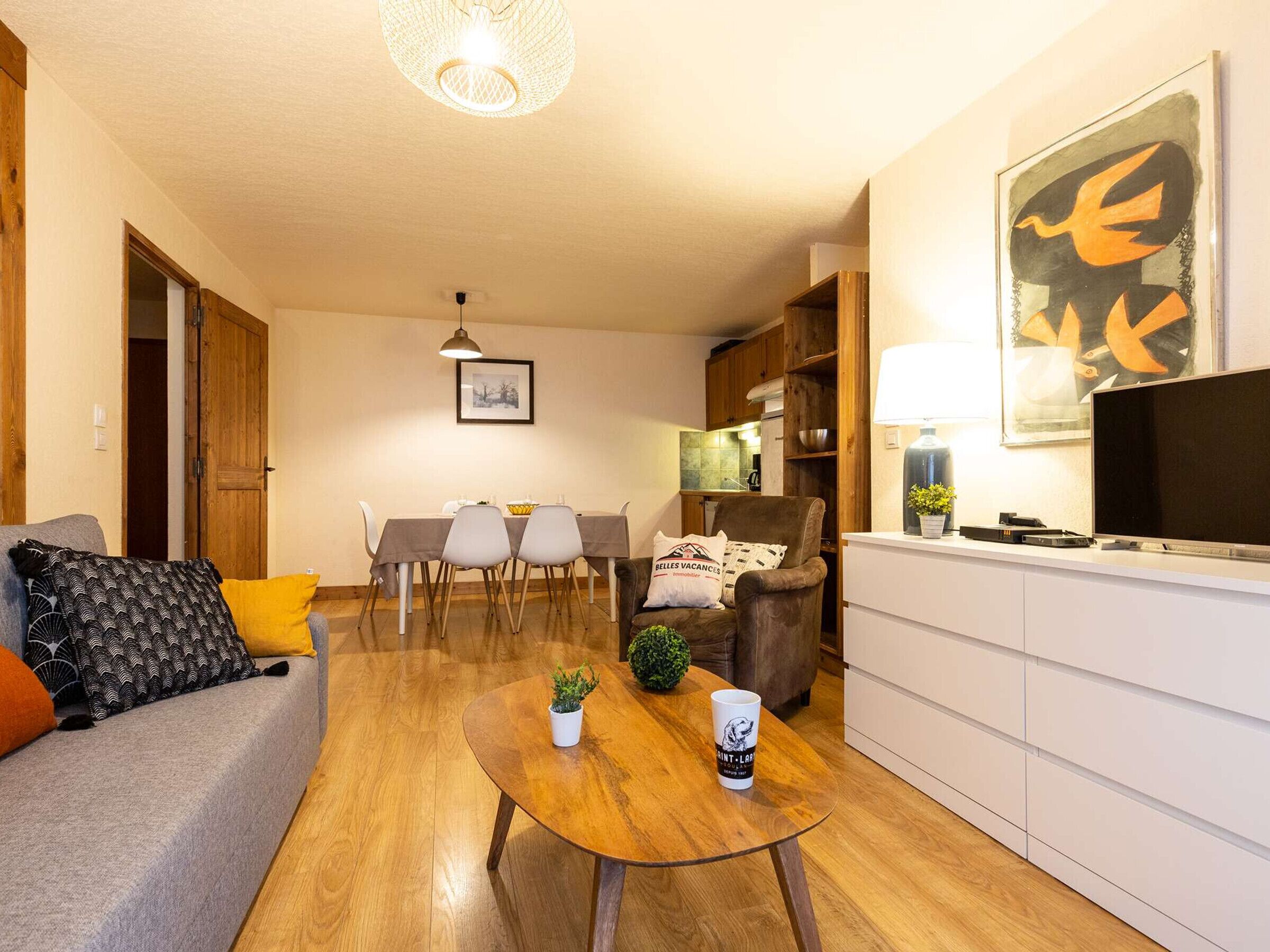 Een moderne woonkamer met een bank, salontafel en een eethoek met stoelen.