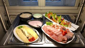 Un bufé con diferentes opciones de comida, como queso, carnes y ensaladas.