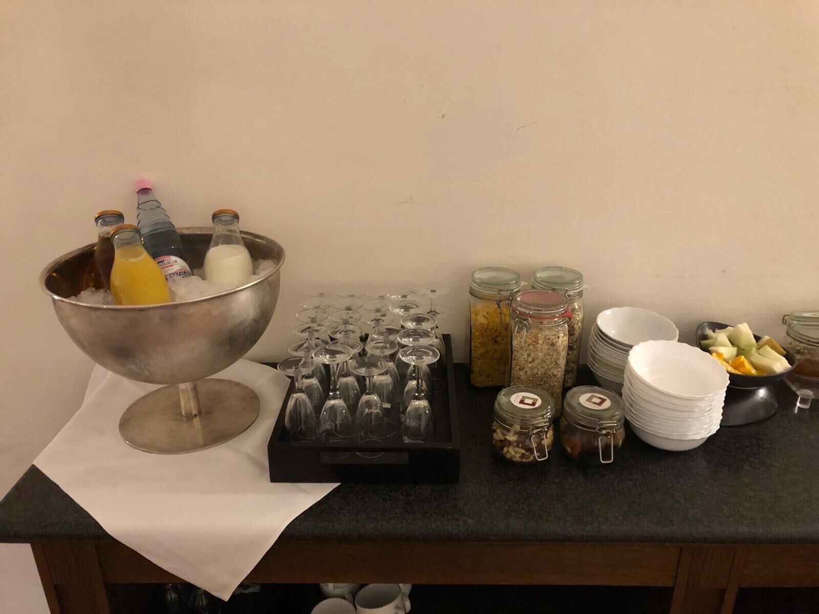A breakfast buffet setup with a variety of food items, drinks, and glassware.