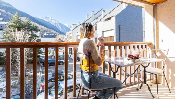Ein Balkon mit Blick auf einen Berg und einen Parkplatz.