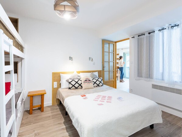 A bedroom with a bed, bedside table, and a window with curtains.