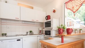 Eine moderne Küche mit weißen Schränken, einer Holz Arbeitsplatte und einem eingebauten Backofen.