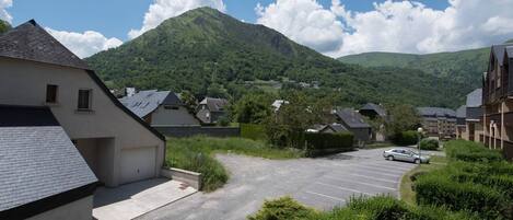 Zona residencial con casas, un estacionamiento y una montaña al fondo.