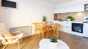 Une cuisine moderne avec des armoires blanches, un plan de travail en bois et un four encastré.