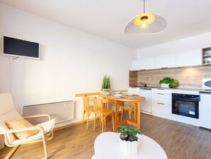 A modern kitchen with white cabinets, a wooden countertop, and a built-in oven.