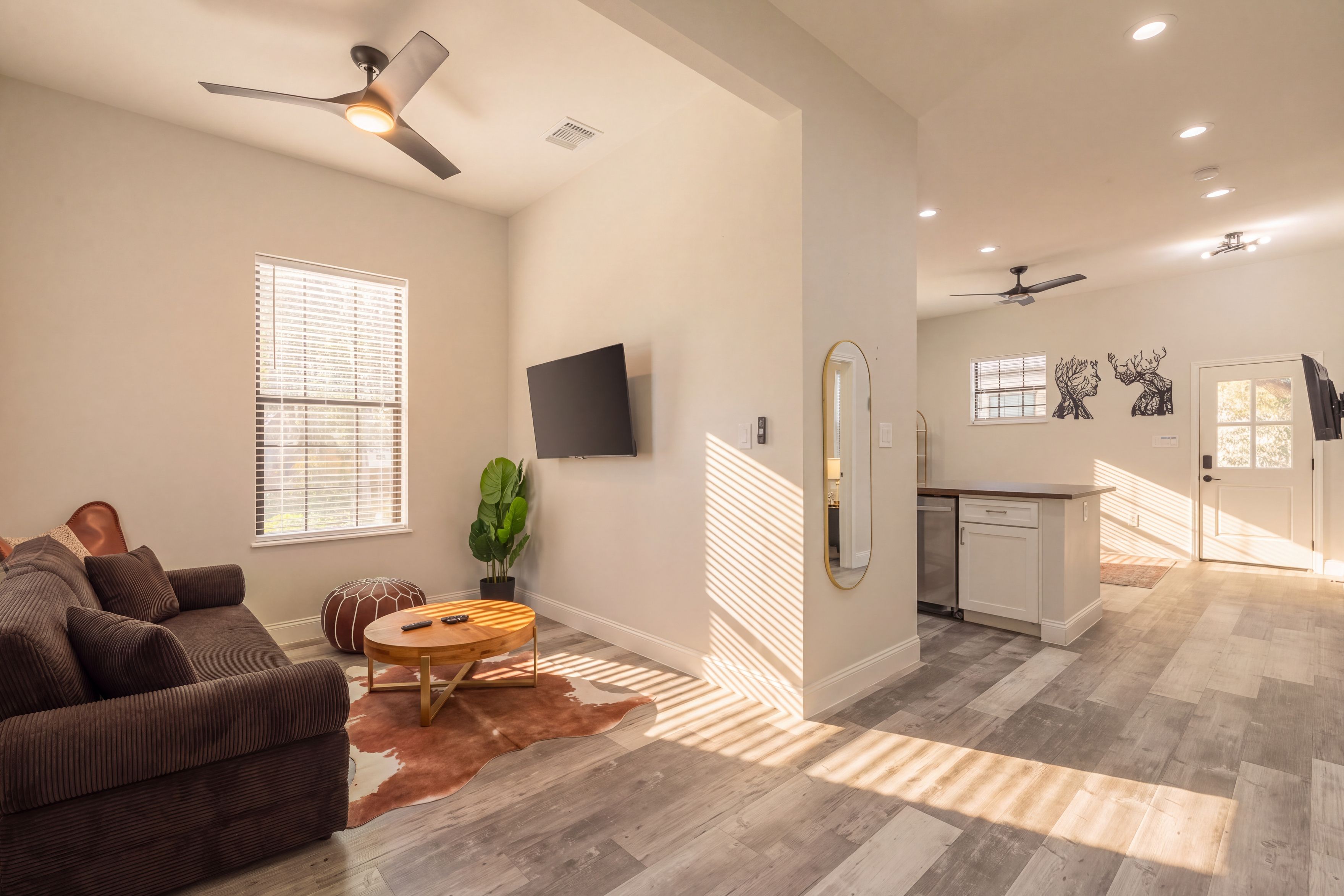 A modern living room with a sofa, a coffee table, and a TV mounted on the wall.