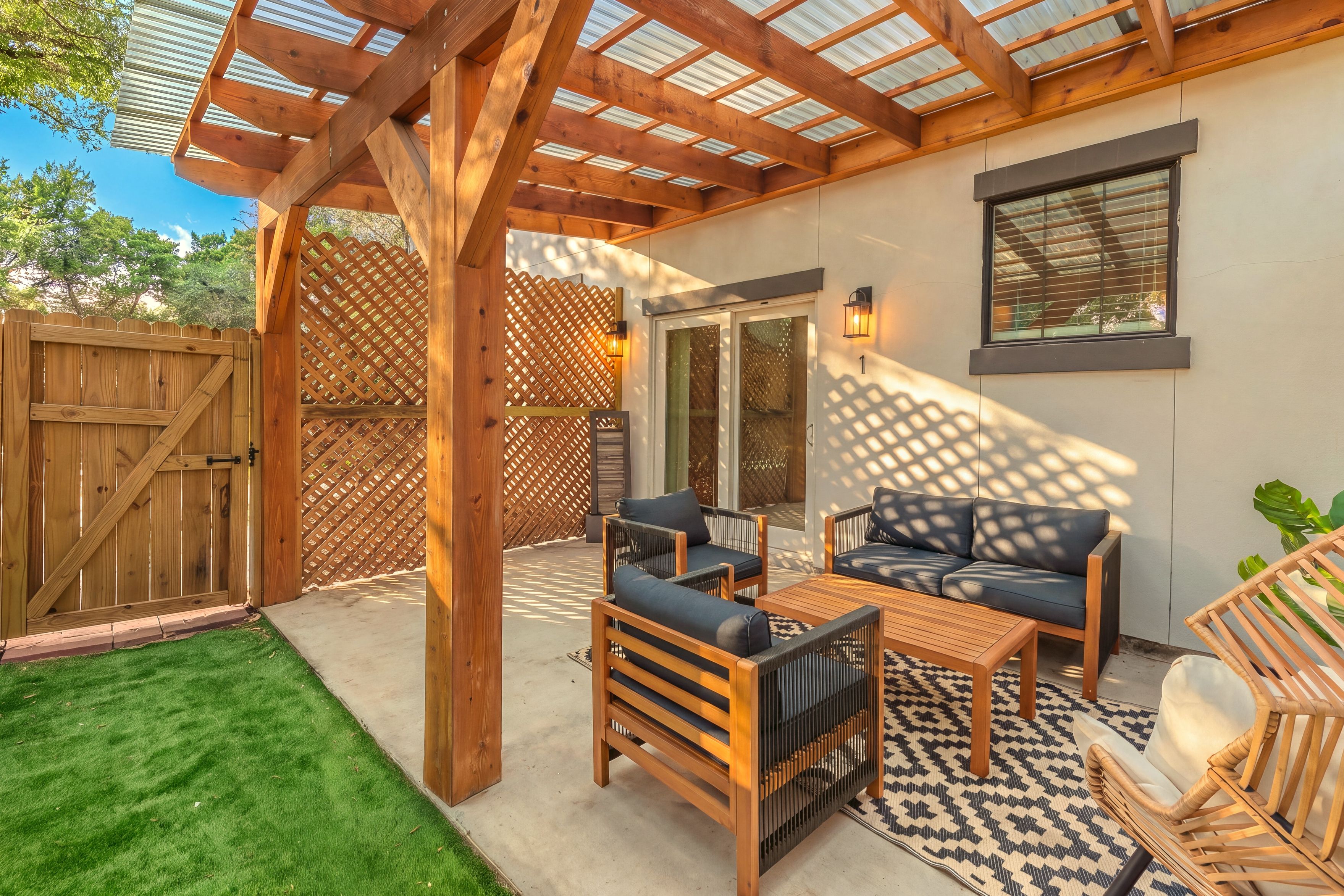 A covered patio area with wooden furniture and a view of the outside.