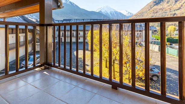 A balcony with a view of mountains and autumn foliage.