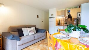 A compact living space with a sofa, dining table, and kitchenette. - Quiet Apartment near Saint-Lary Center, 700m from Cable Car, Max 5 People (Saint-Lary-Soulan)