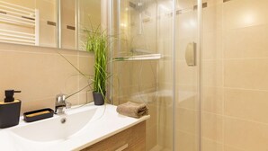 A modern bathroom with a glass shower enclosure, a white sink, and a mirror. - Quiet apartment Saint Lary, 4 people, near center, wifi included (Saint-Lary-Soulan)