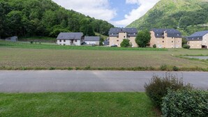A residential area with multiple apartment buildings, a paved road, and a green field. - Quiet apartment Saint Lary, 4 people, near center, wifi included (Saint-Lary-Soulan)