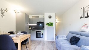 A compact living space with a dining area, kitchenette, and a sofa. - Quiet apartment Saint Lary, 4 people, near center, wifi included (Saint-Lary-Soulan)