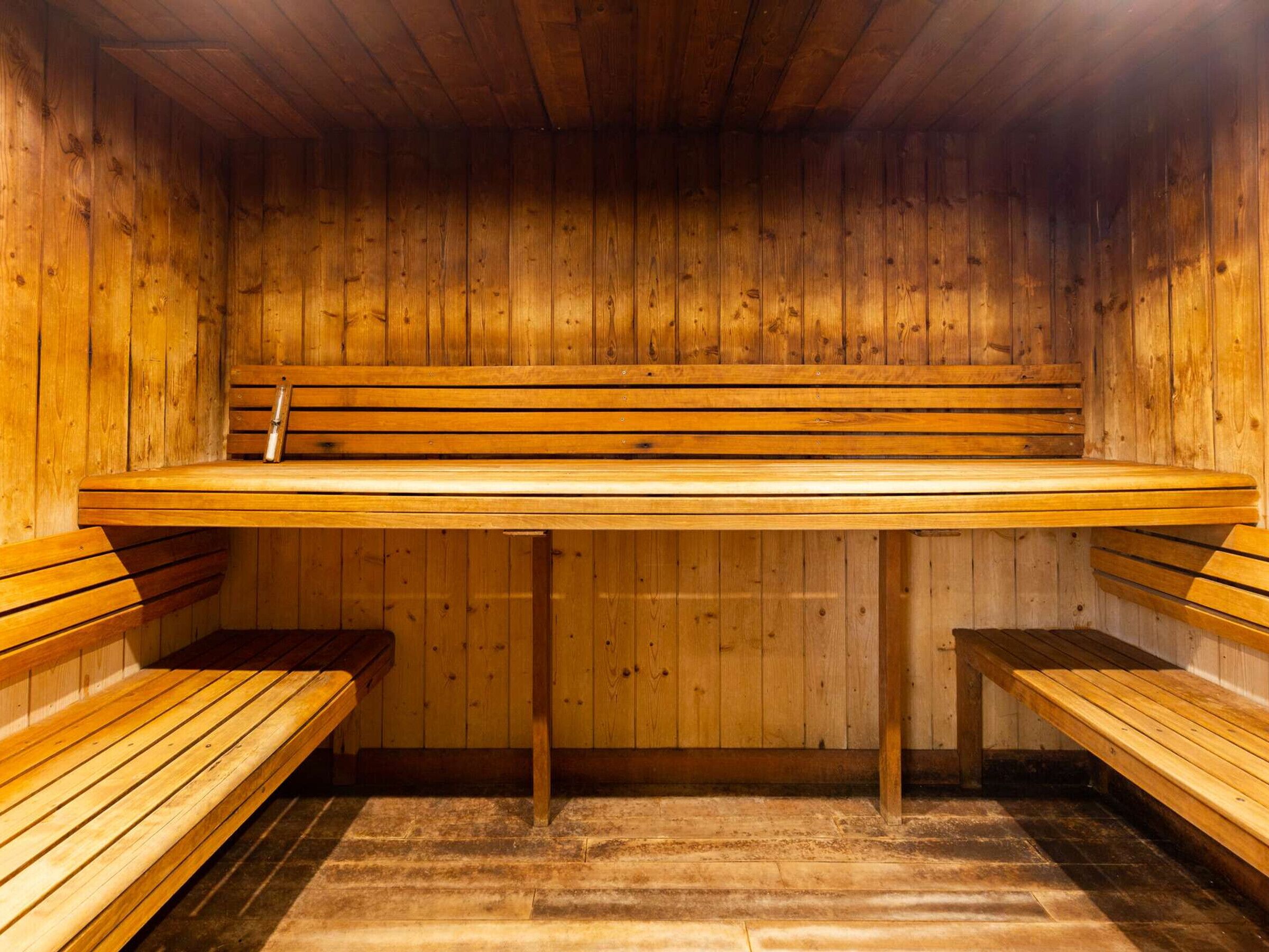 Uma sauna com bancos de madeira e um assento de banco.