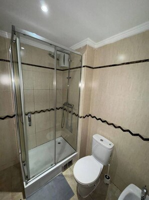 Ein Badezimmer mit Duschkabine, Toilette und Bidet.