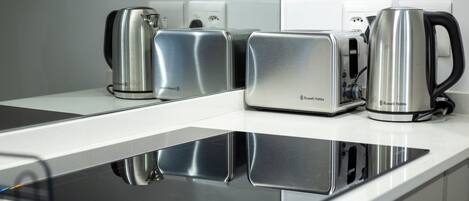 A modern kitchen with a built-in induction cooktop, a toaster, and a kettle.