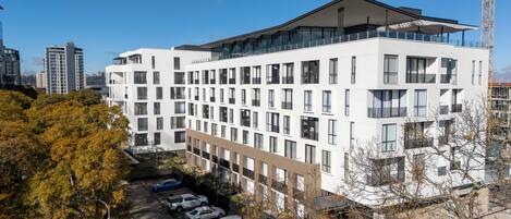 A modern multi-story building with a flat roof and large windows.