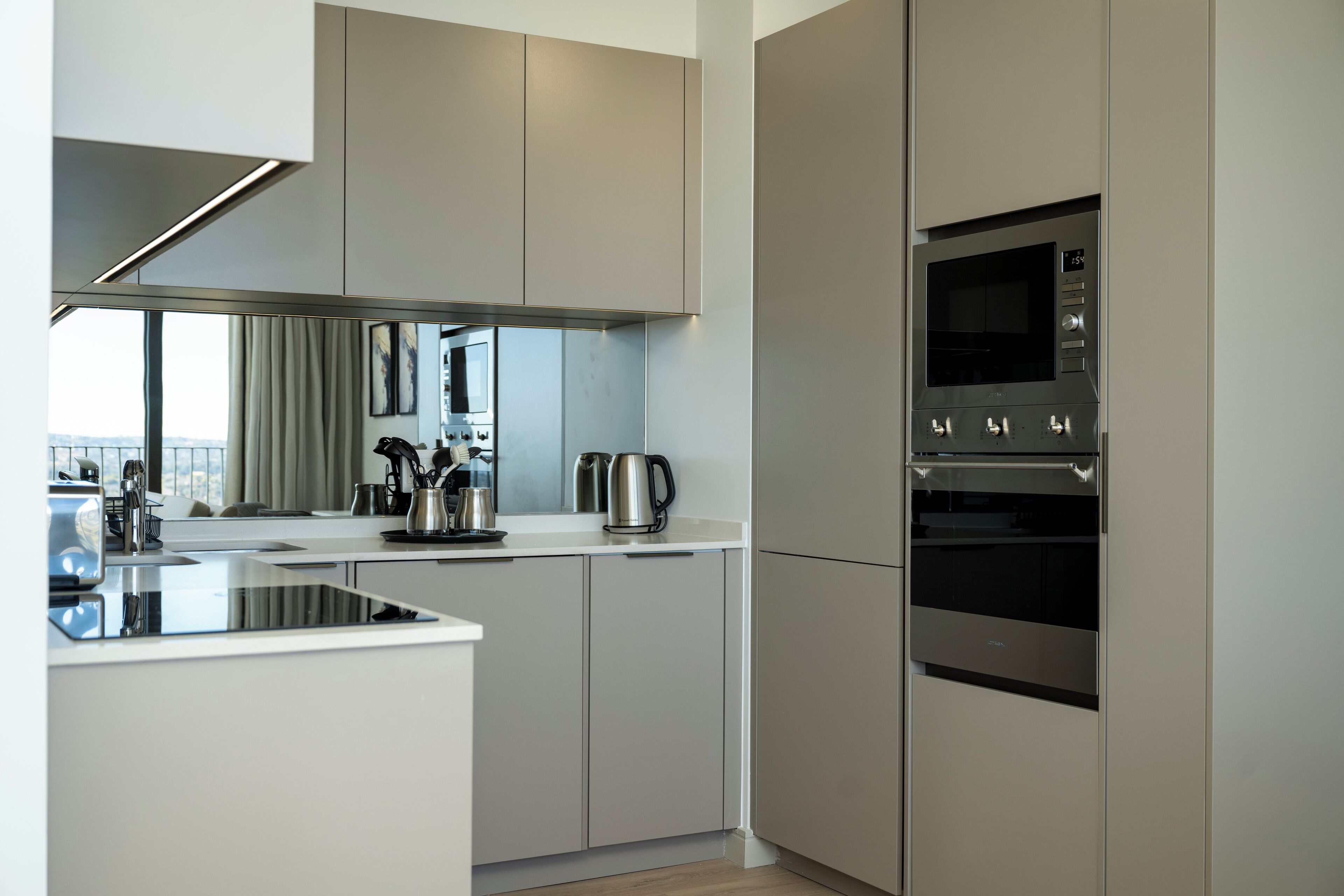 A modern kitchen with stainless steel appliances, a large island, and a view of the city.