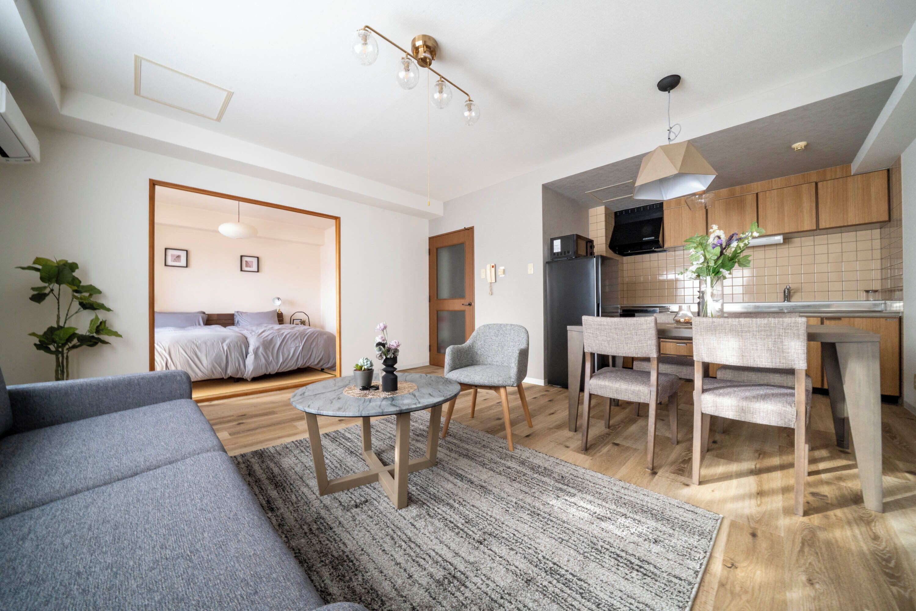 A modern apartment with a living room, dining area, and kitchen.