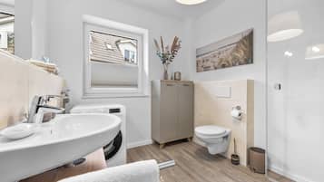 Ein modernes Badezimmer mit Waschbecken, Toilette und Fenster.