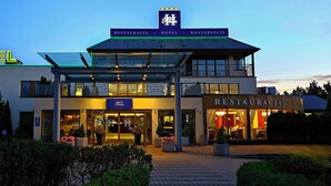 A hotel with a glass facade, a restaurant, and a sign indicating it is a conference venue. - Hotel Great Polonia Kraków Airport (Modlniczka)