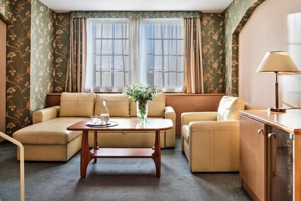 A room with a sofa set, a wooden coffee table, and a cabinet.