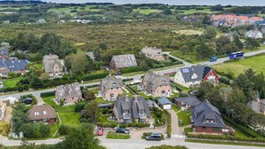 Vue aérienne d’un quartier résidentiel avec des maisons, une route et un autobus.