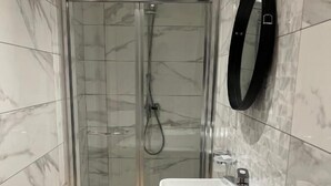 A modern bathroom with a glass-enclosed shower, a white sink, and a black-framed mirror. - STAY AT 9020 (St. Paul's Bay)
