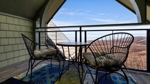 Un balcon avec une table et deux chaises, offrant une vue sur un paysage magnifique.