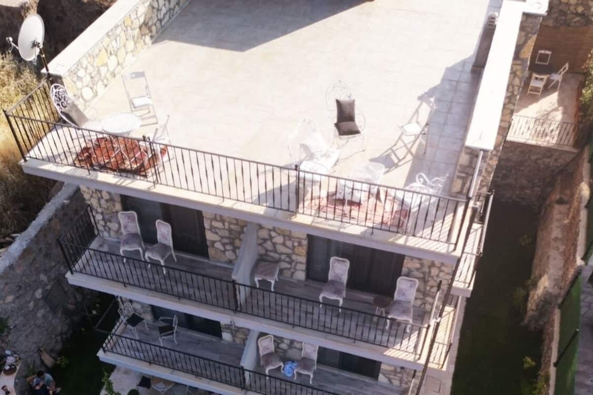 Un immeuble à plusieurs étages doté d’espaces extérieurs aménagés, comprenant des tables et des chaises, ainsi qu’un petit espace piscine.