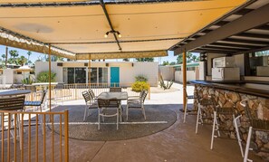 An outdoor patio with a stone bar, tables, and chairs. - Desert Dream - OCotillo Lodge with Fitness Center (Palm Springs)